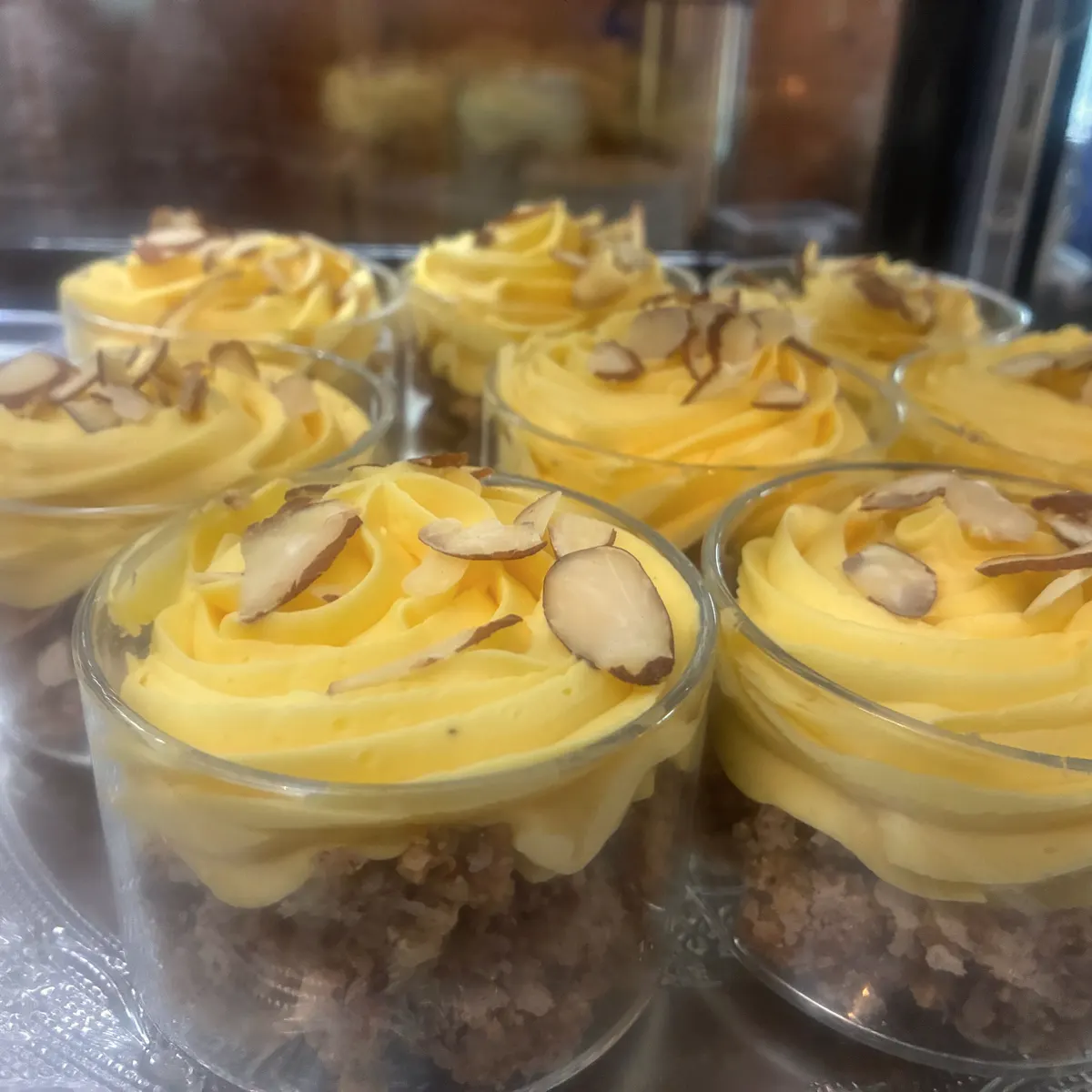 Dessertglass med gul krem og mandelflak